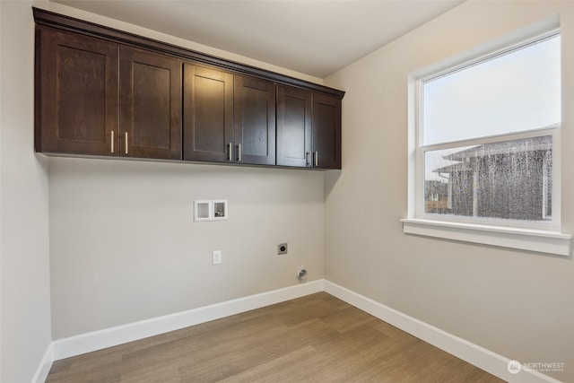 laundry area featuring plenty of natural light, hardwood / wood-style flooring, and electric dryer hookup