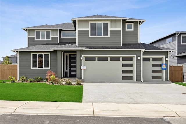 prairie-style home with a front yard and a garage