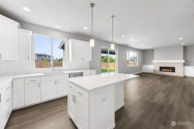 kitchen featuring backsplash, hardwood / wood-style flooring, and a healthy amount of sunlight