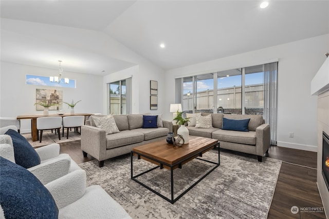 living room featuring vaulted ceiling, dark wood-type flooring, and an inviting chandelier