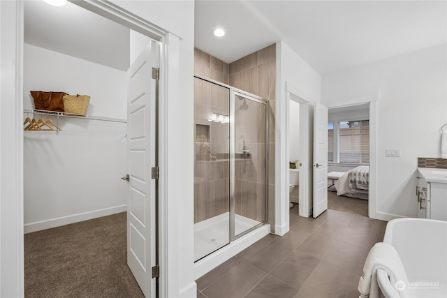 bathroom with toilet, vanity, and a shower with shower door