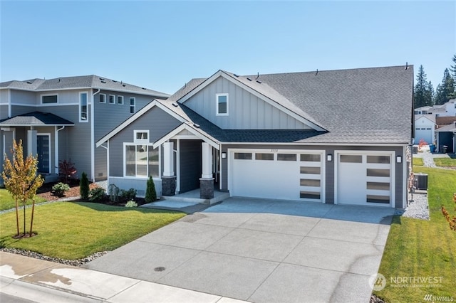 view of front of house with central AC unit, a front yard, and a garage