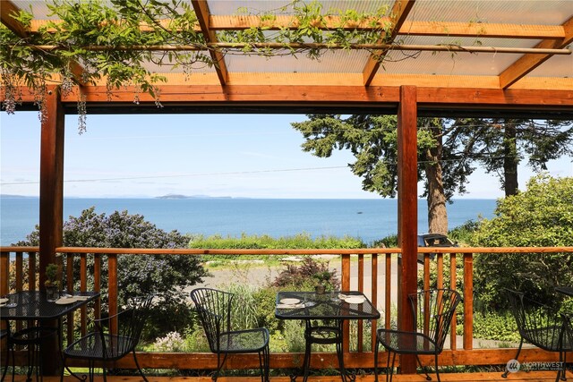 exterior space featuring a water view and a pergola