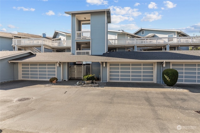 view of front of property featuring a balcony and a garage