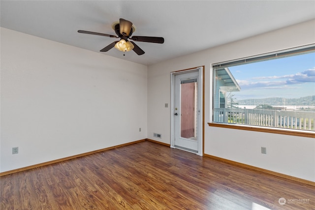 unfurnished room featuring dark hardwood / wood-style floors and ceiling fan