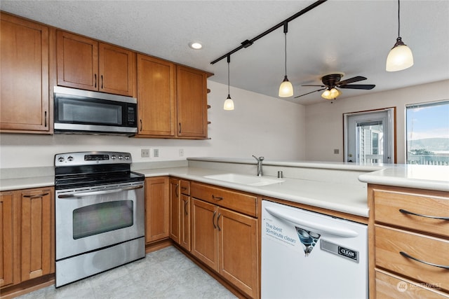 kitchen featuring light tile floors, stainless steel appliances, pendant lighting, ceiling fan, and sink