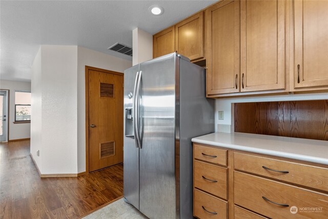 kitchen with light hardwood / wood-style floors and stainless steel refrigerator with ice dispenser