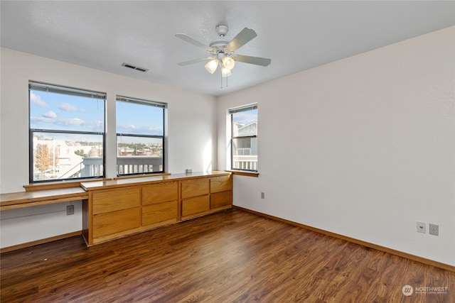 empty room with ceiling fan and dark wood-type flooring