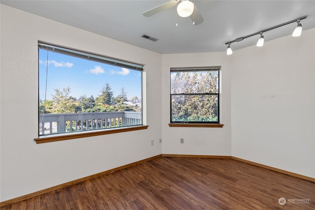 unfurnished room featuring rail lighting, wood-type flooring, and ceiling fan