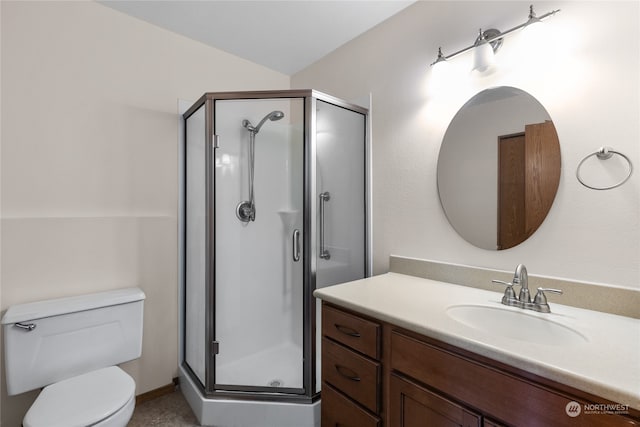 bathroom featuring a shower with door, toilet, and vanity