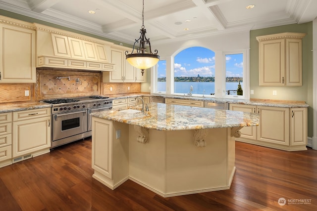 kitchen with double oven range, cream cabinets, and decorative backsplash