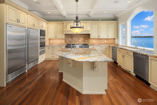 kitchen featuring built in appliances, cream cabinetry, and decorative backsplash