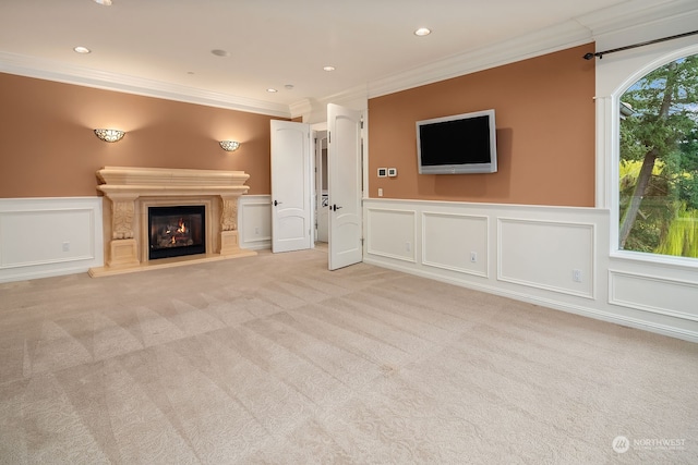 unfurnished living room featuring light colored carpet, a fireplace, and crown molding