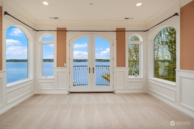 unfurnished sunroom with a healthy amount of sunlight, french doors, and a water view