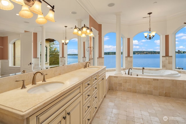 bathroom with tiled tub, a water view, and an inviting chandelier