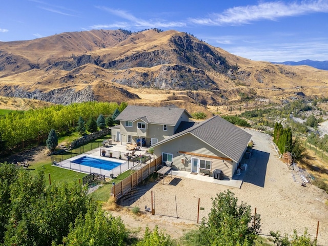 view of subject property featuring a pool and a mountainous background