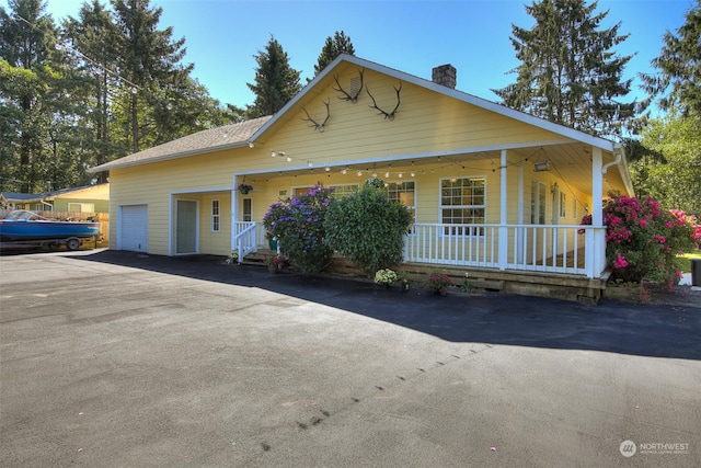 view of front of property featuring covered porch and a garage