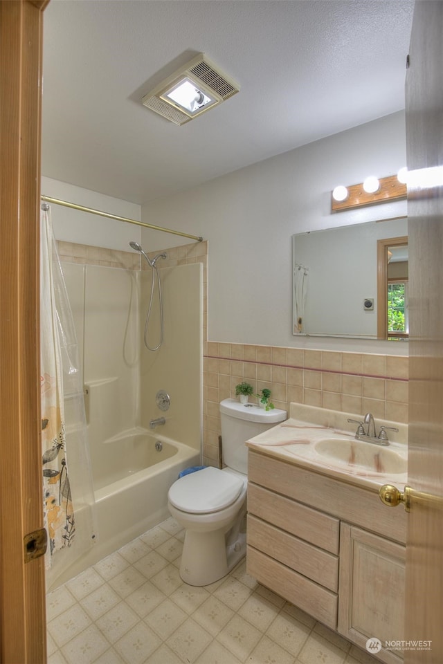 full bathroom featuring toilet, shower / bath combo with shower curtain, backsplash, tile flooring, and vanity