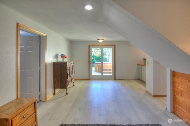 bonus room with light hardwood / wood-style floors and vaulted ceiling