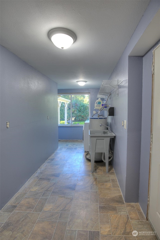 hallway featuring dark tile floors and a textured ceiling