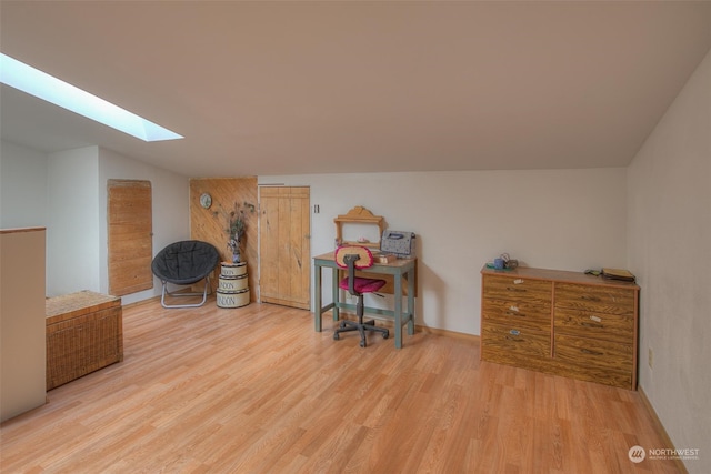 interior space with vaulted ceiling with skylight and light wood-type flooring