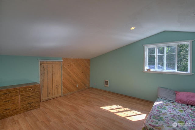 bonus room featuring light wood-type flooring and vaulted ceiling