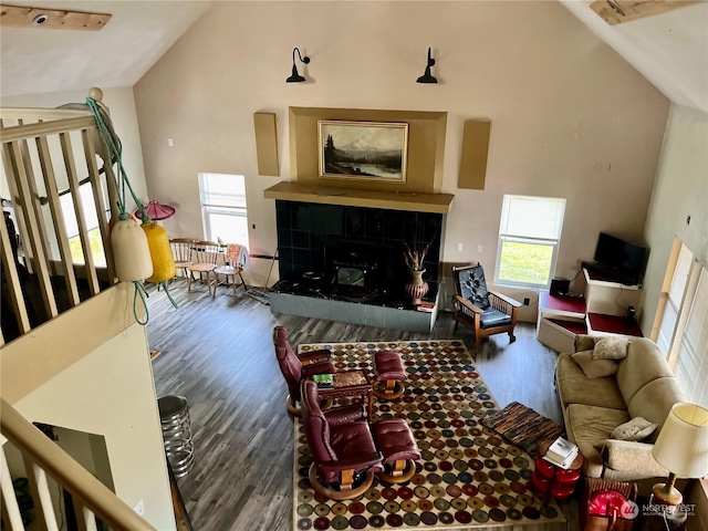 living room featuring dark wood-type flooring, a fireplace, and high vaulted ceiling