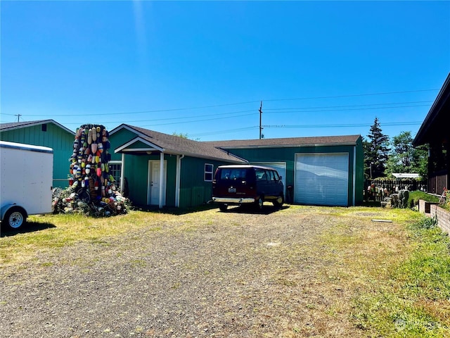 single story home featuring a garage and an outbuilding