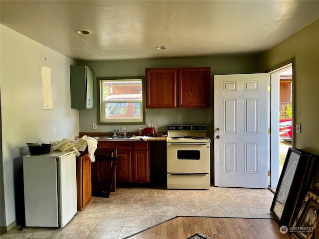 kitchen with fridge, sink, and white electric range oven