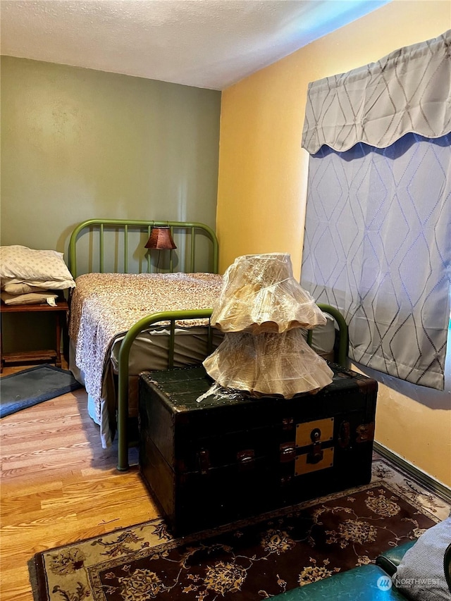 bedroom with hardwood / wood-style flooring and a textured ceiling