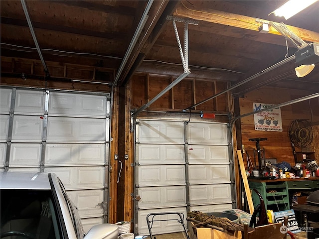 garage featuring a garage door opener and wood walls