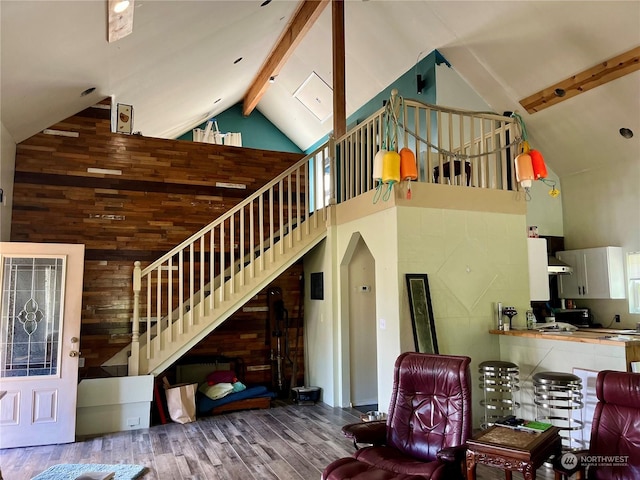 living room featuring hardwood / wood-style floors, high vaulted ceiling, and beamed ceiling