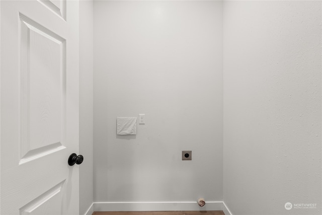 washroom with hookup for an electric dryer and hardwood / wood-style flooring