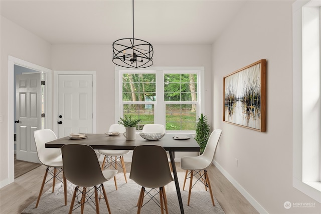 dining room featuring light wood-type flooring and a chandelier