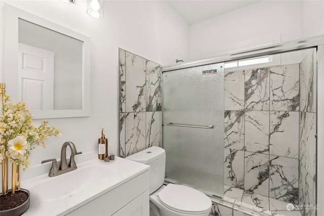 bathroom featuring vanity, a shower with door, and toilet