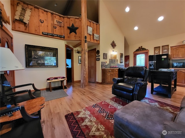 living room with high vaulted ceiling and light hardwood / wood-style flooring