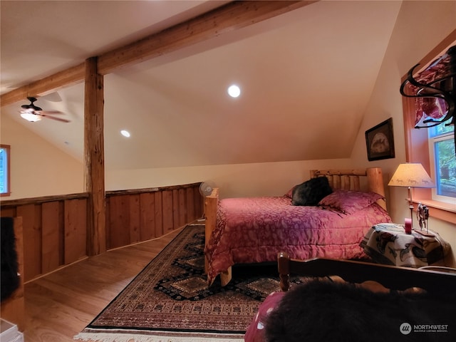 bedroom with ceiling fan, lofted ceiling with beams, wood walls, and hardwood / wood-style flooring