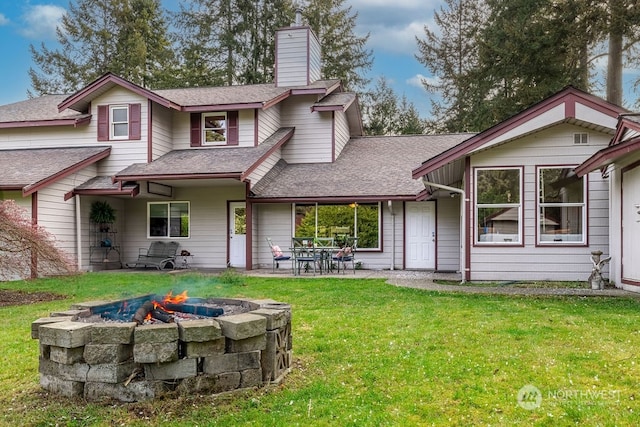 rear view of house featuring a fire pit, a yard, and a patio area