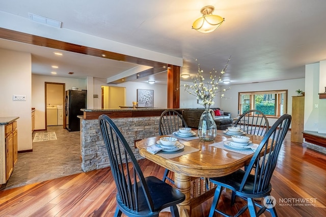 tiled dining space featuring washer and dryer