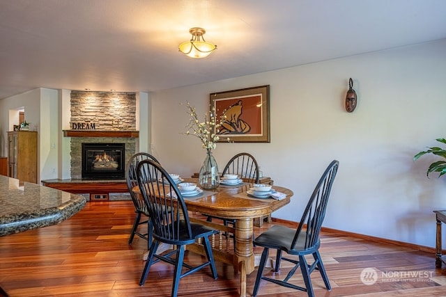 dining area featuring a fireplace and wood-type flooring