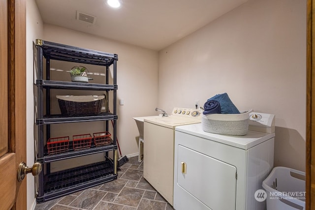 laundry area with independent washer and dryer and dark tile flooring