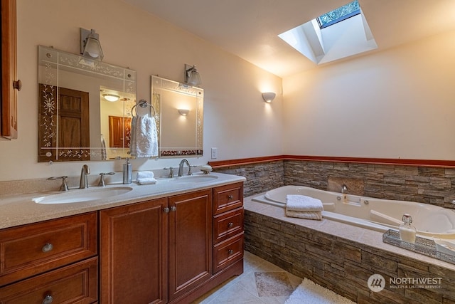 bathroom featuring tiled bath, tile flooring, vaulted ceiling with skylight, vanity with extensive cabinet space, and double sink