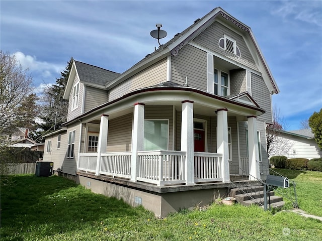 view of front of home featuring a front yard, central AC unit, and a porch