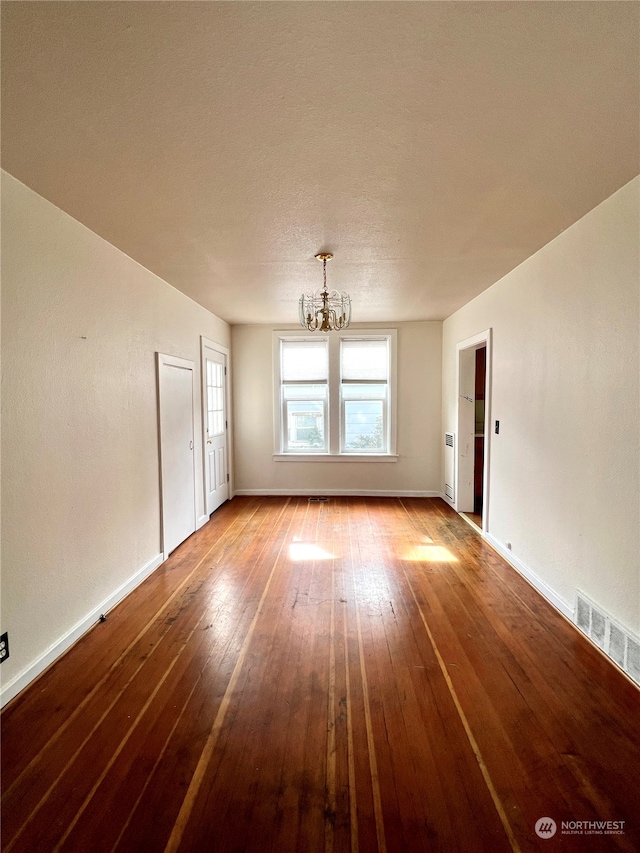 spare room with light hardwood / wood-style floors and a notable chandelier
