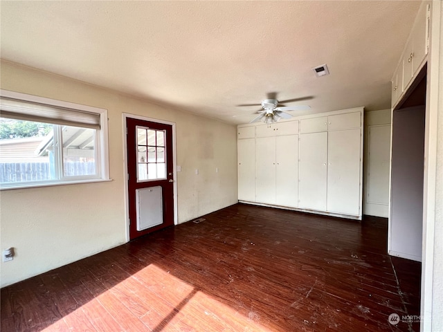 spare room with a textured ceiling, radiator heating unit, ceiling fan, and dark hardwood / wood-style flooring