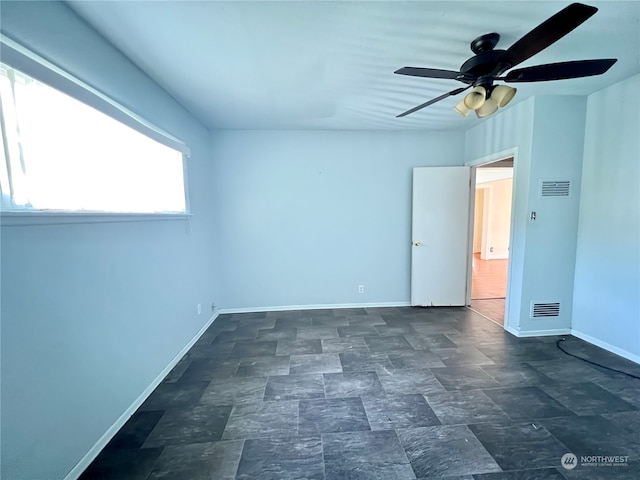 unfurnished room featuring dark tile floors and ceiling fan