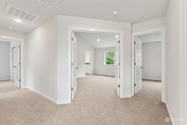 hall featuring light carpet and lofted ceiling