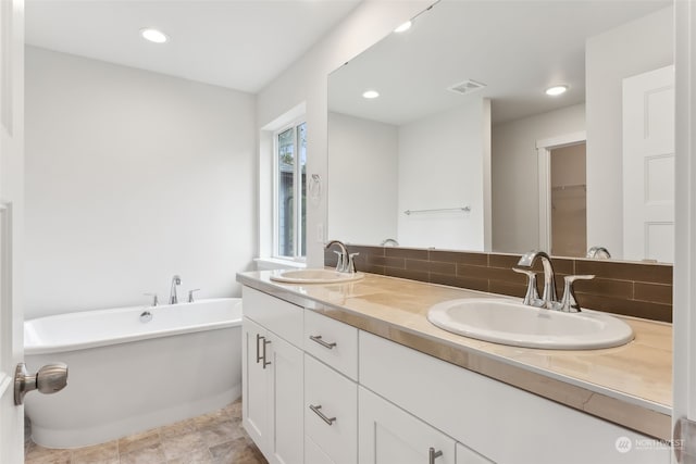 bathroom with vanity, a bathtub, and backsplash