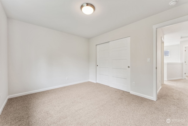 unfurnished bedroom featuring carpet and a closet