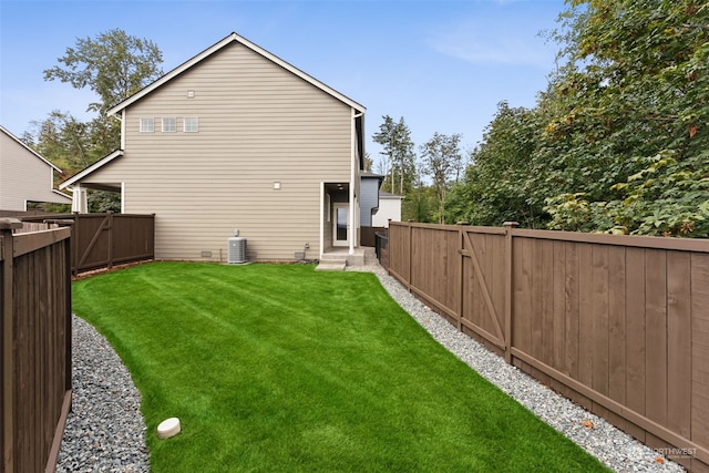 rear view of house featuring cooling unit and a lawn